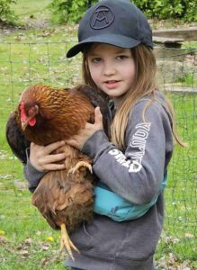 Junges Mädchen bei LeNa hält Huhn in den Armen