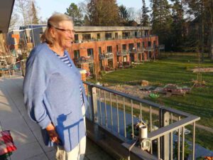 Unsere LeNa-Seniorin Jutta schaut von ihrem Balkon in den Park