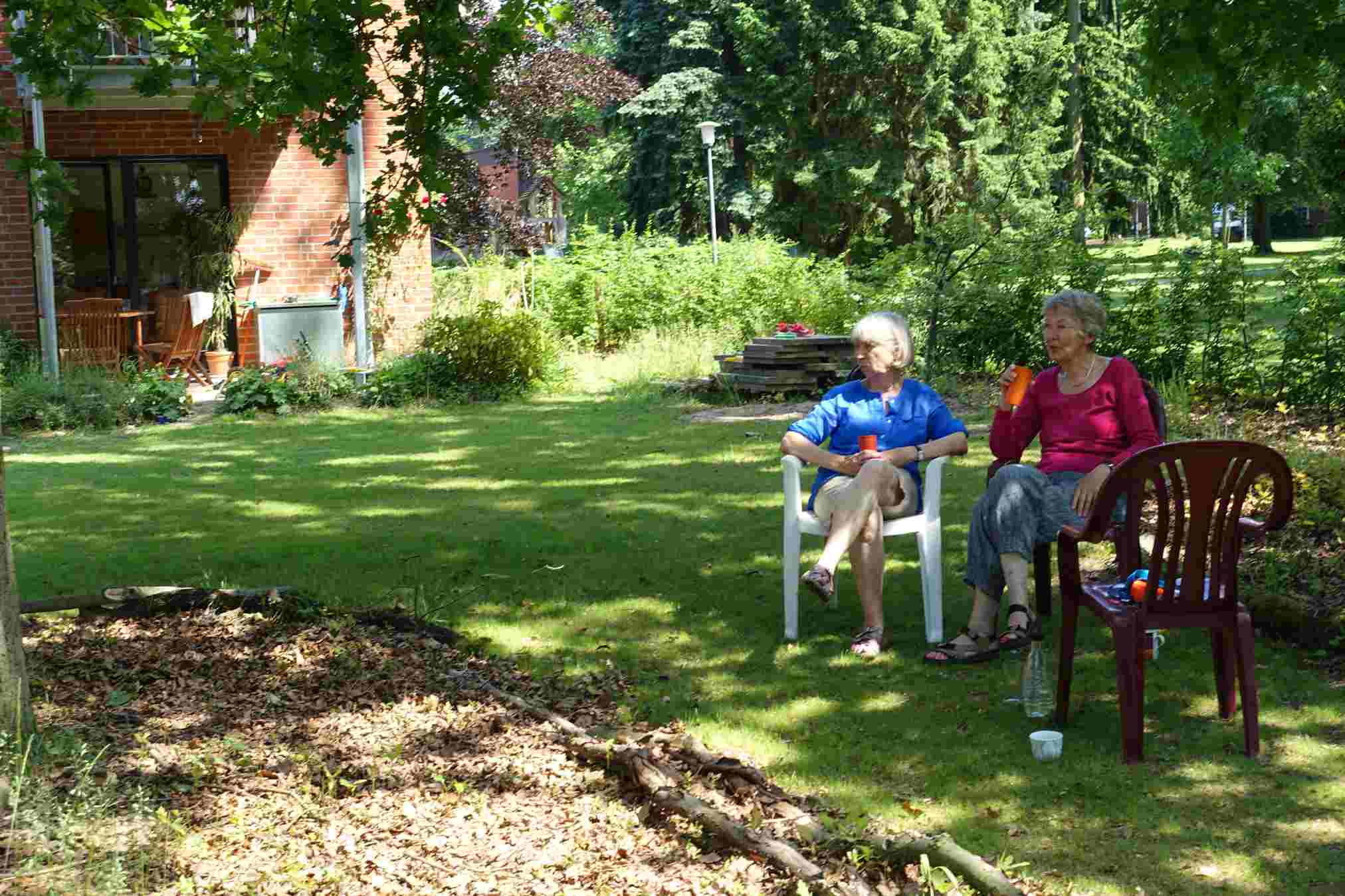 Zwei Seniorinnen bei LeNa sitzen in der "Ruheecke" unter alten Eichen