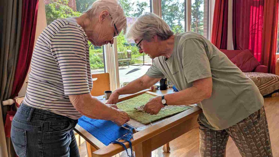 2 Frauen arbeiten an Webbild halbtotal