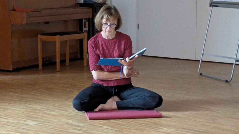 Frau sitzend, Vorlesen eines Textes zur Meditation